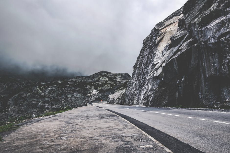 Empty mountain road through foggy Swiss landscapes, perfect for travel and adventure themes.